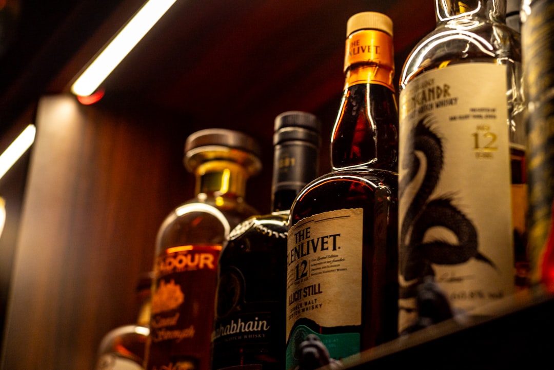 single malt whisky bottles lineup, scotch whisky glass amber light