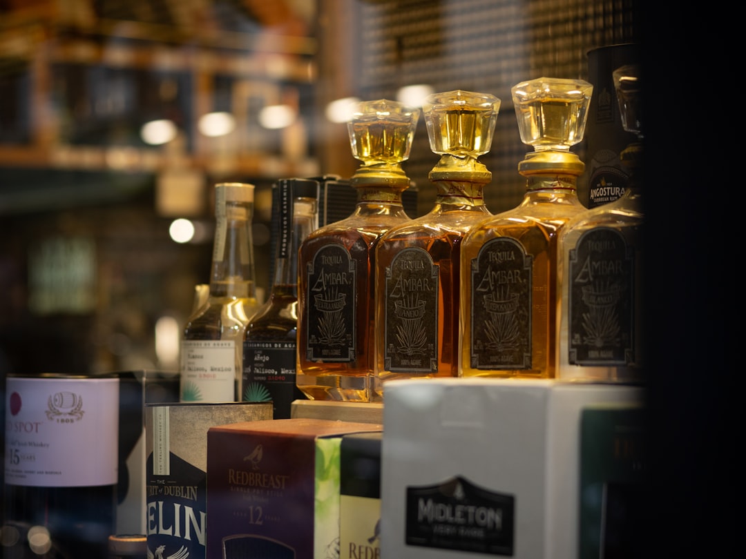 single malt whisky bottles lineup shelf, scotch whisky tasting glass amber